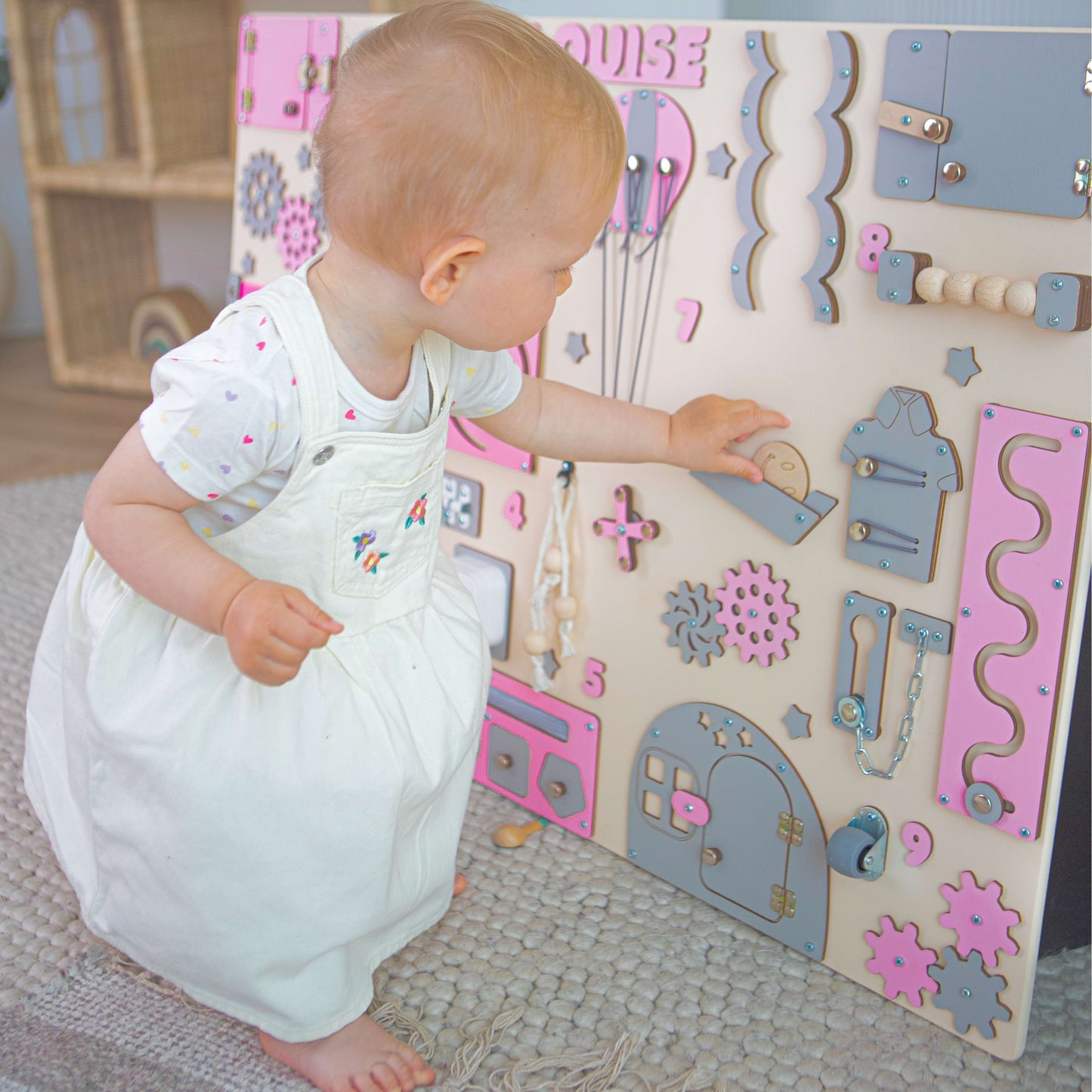 Child playing with a wooden activity board in a child-friendly room.