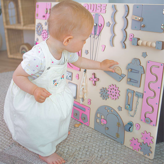 Child playing with a wooden activity board in a child-friendly room.
