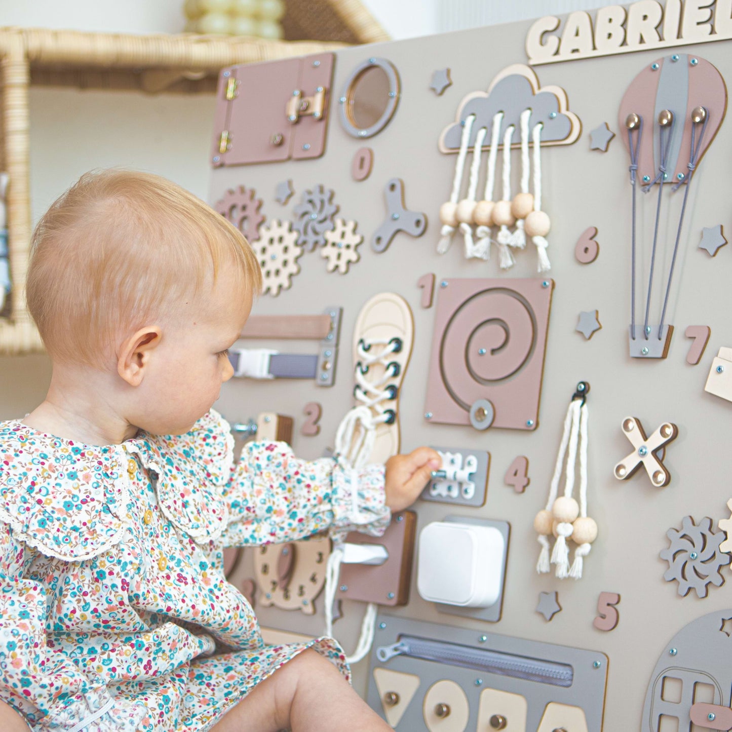 Child interacting with a wooden activity panel on a wall