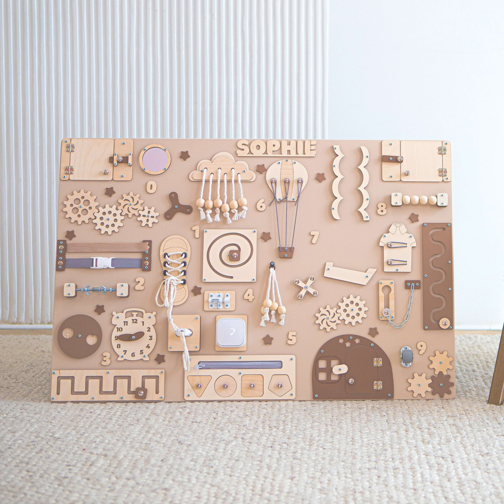 Holz motorikboard mit verschiedenen Formen und Mechanismen auf hellem Hintergrund