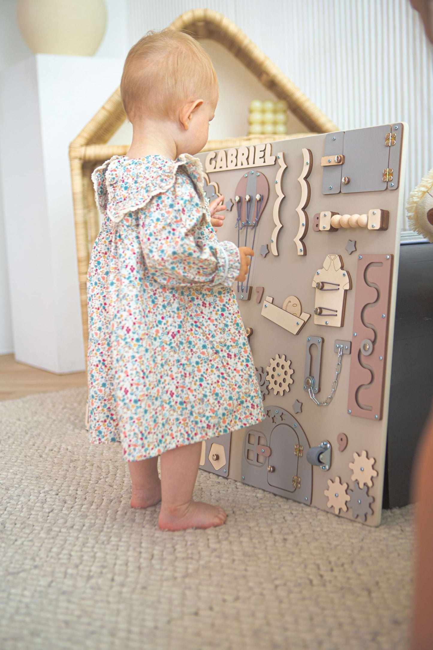 toddler playing with a wooden activity board in a home