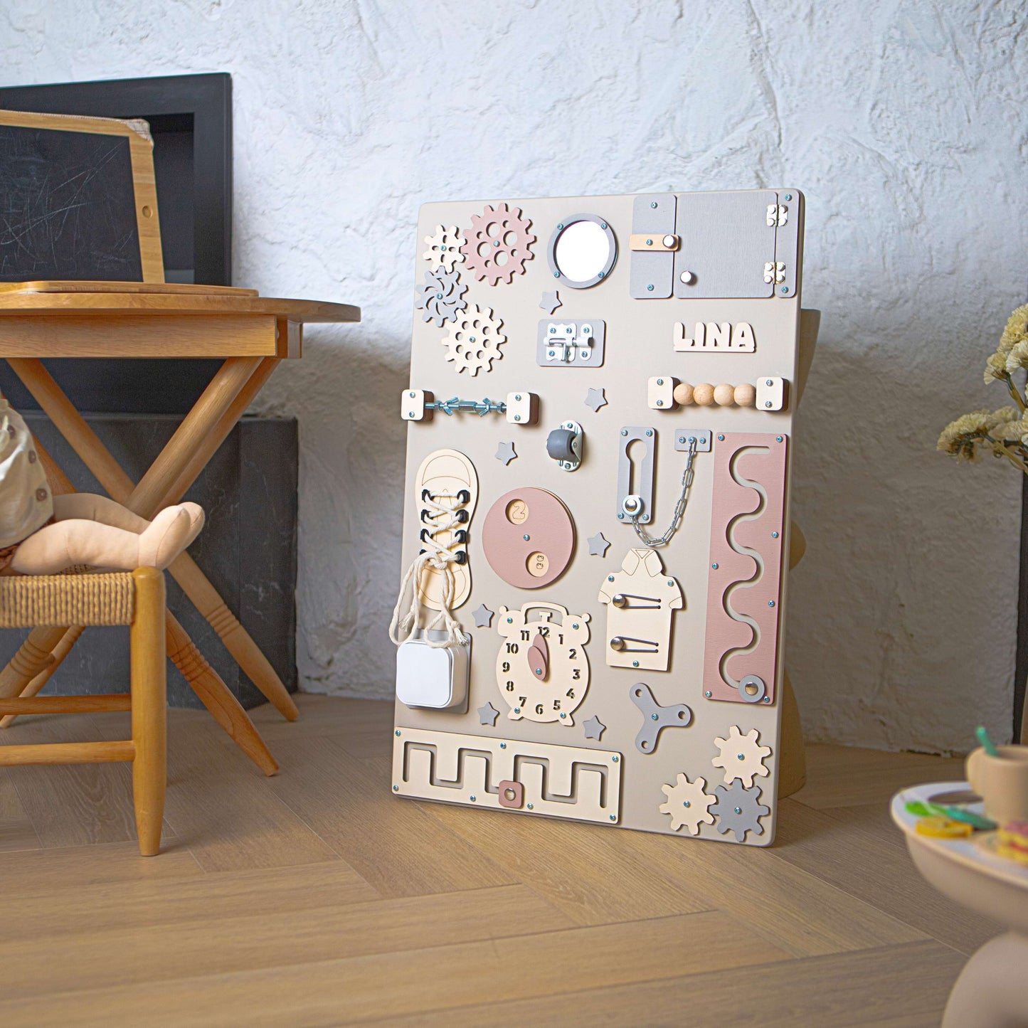 Table d'activités pour enfants avec divers éléments éducatifs sur un plancher en bois.