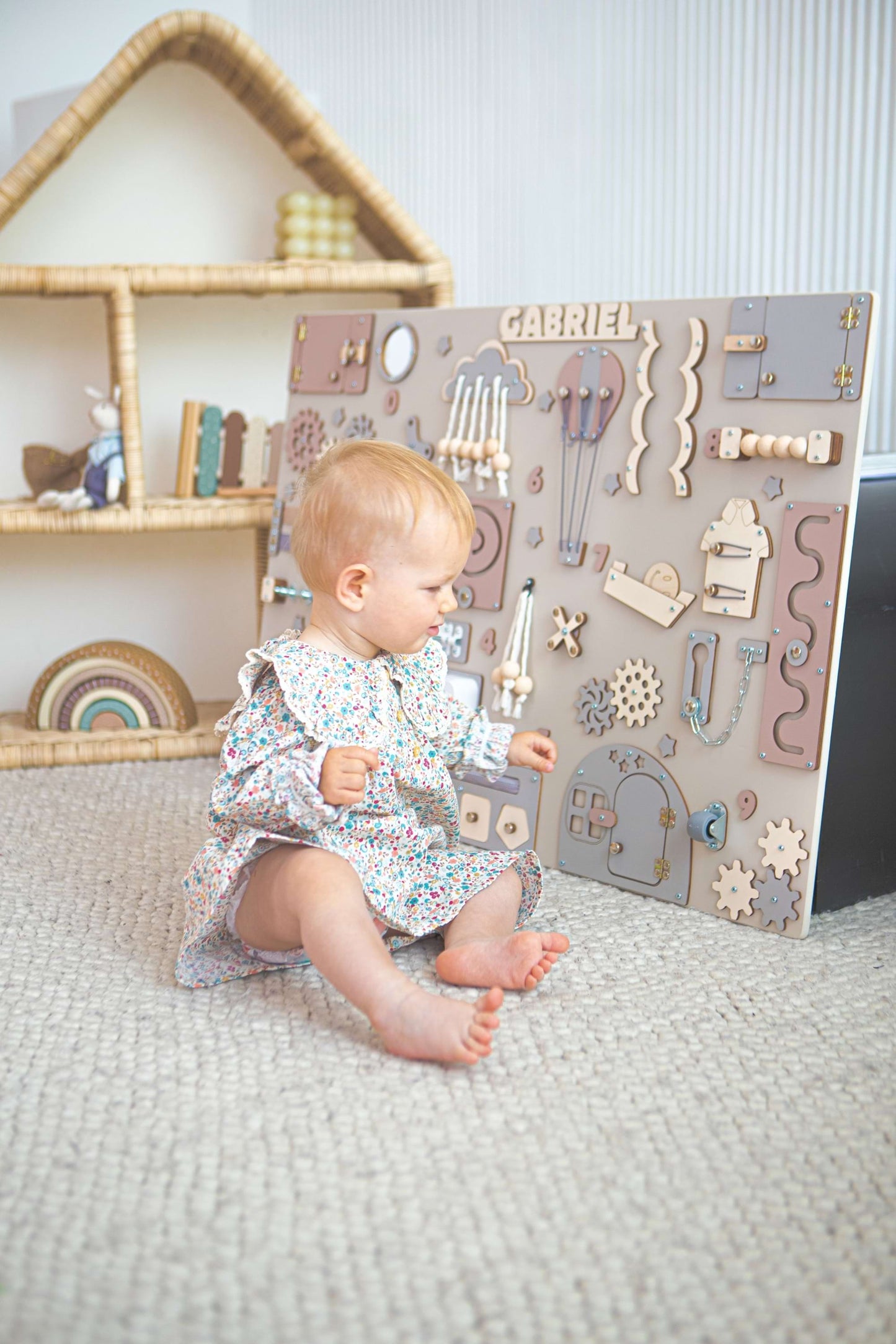 Bébé jouant avec un tableau d'activités en bois dans une chambre d'enfant