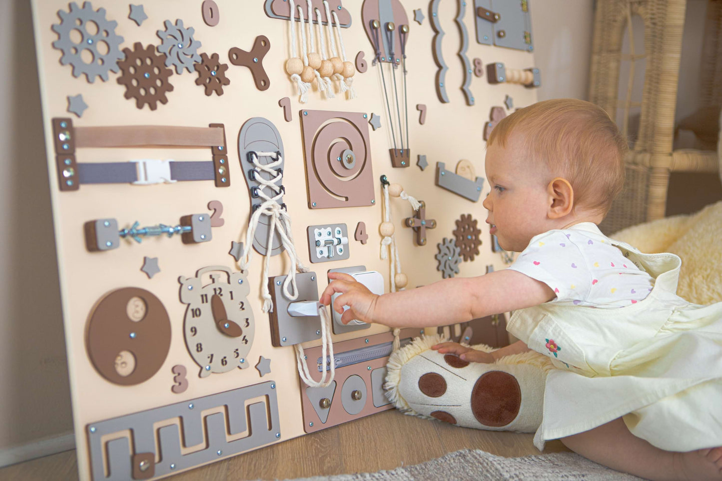Bébé jouant avec un panneau d'activités en bois dans un cadre familial