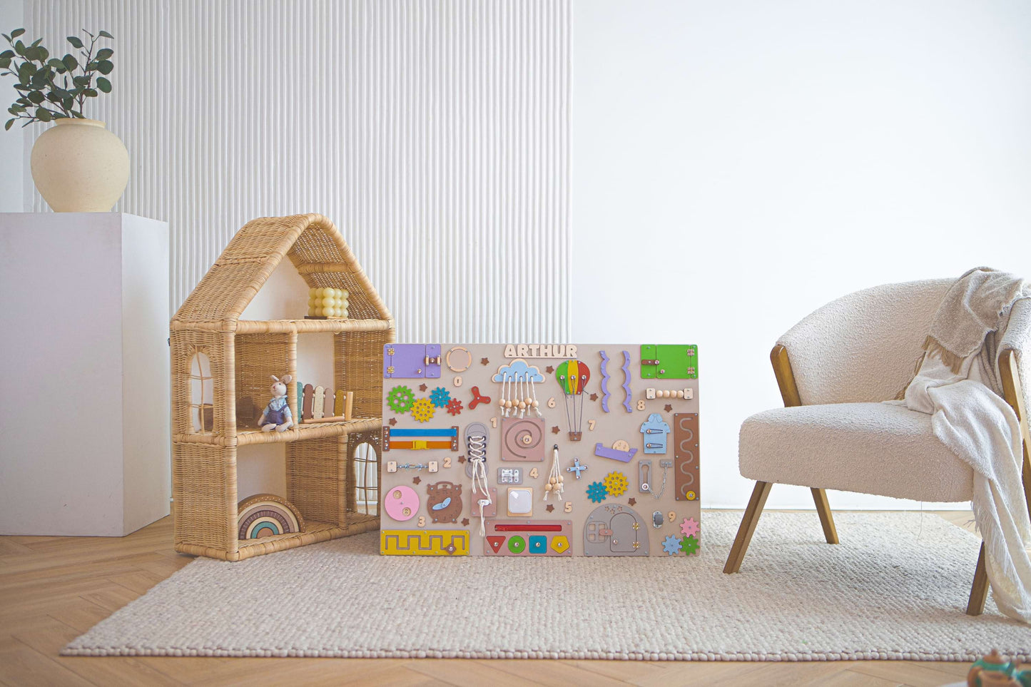 Tableau d'activités Montessori pour enfants et boîte à puzzles dans une pièce avec une chaise et une plante.