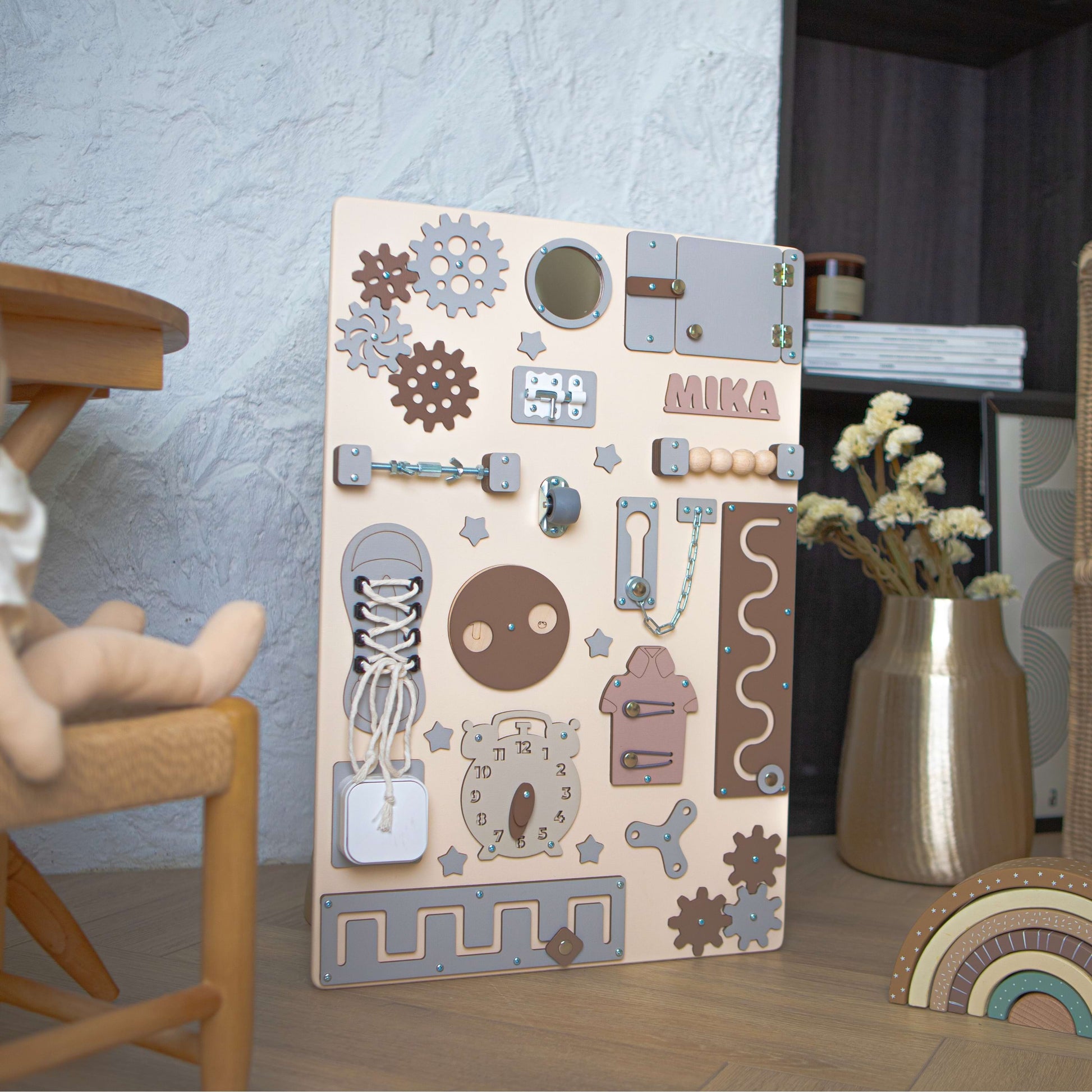 Children's play area with a wooden activity board, doll, and small table.