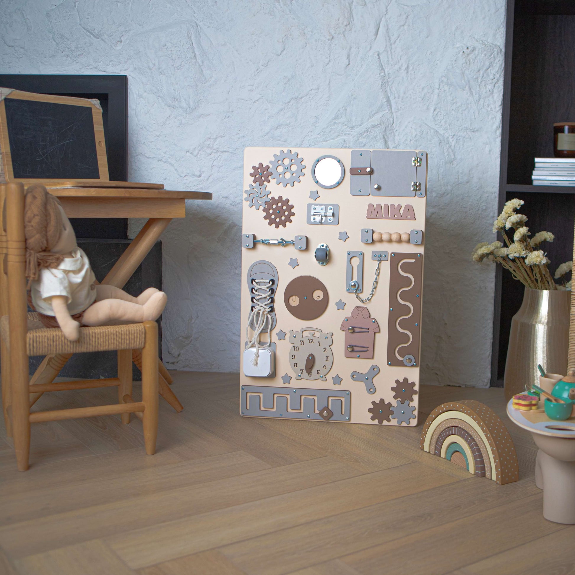 Kinderspielbereich mit einem Aktivitätsbrett aus Holz, einer Puppe und einem kleinen Tisch