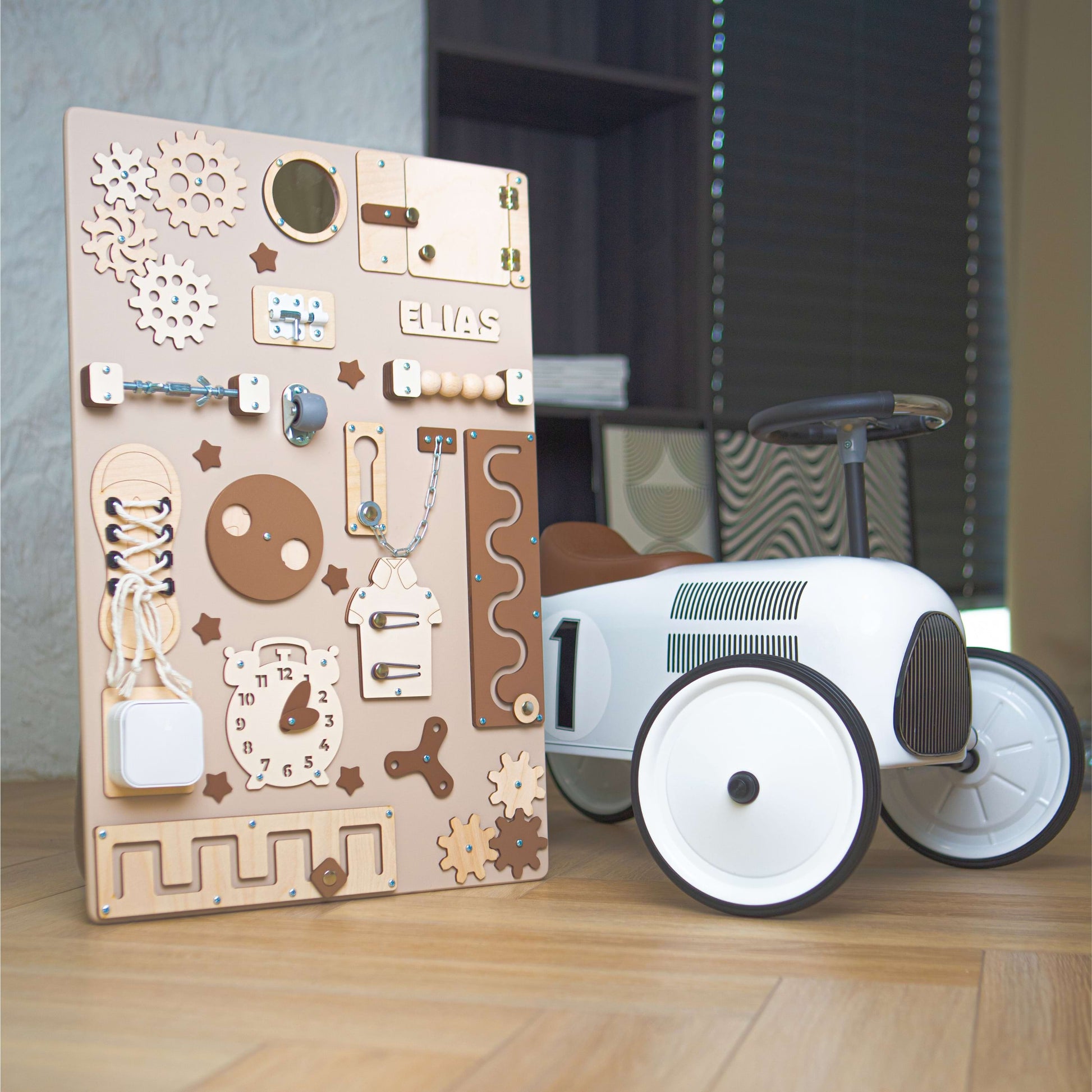 busy board en bois avec conception mécanique et petite voiture sur un sol en bois.