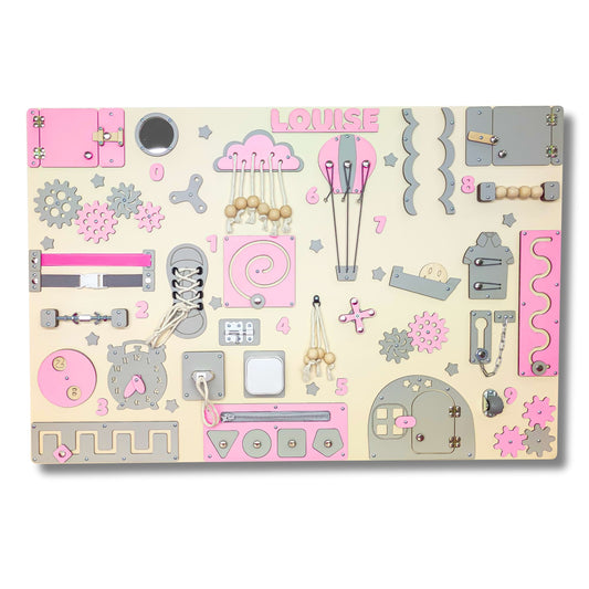 Children's pink busy board with various shapes and designs on a beige background