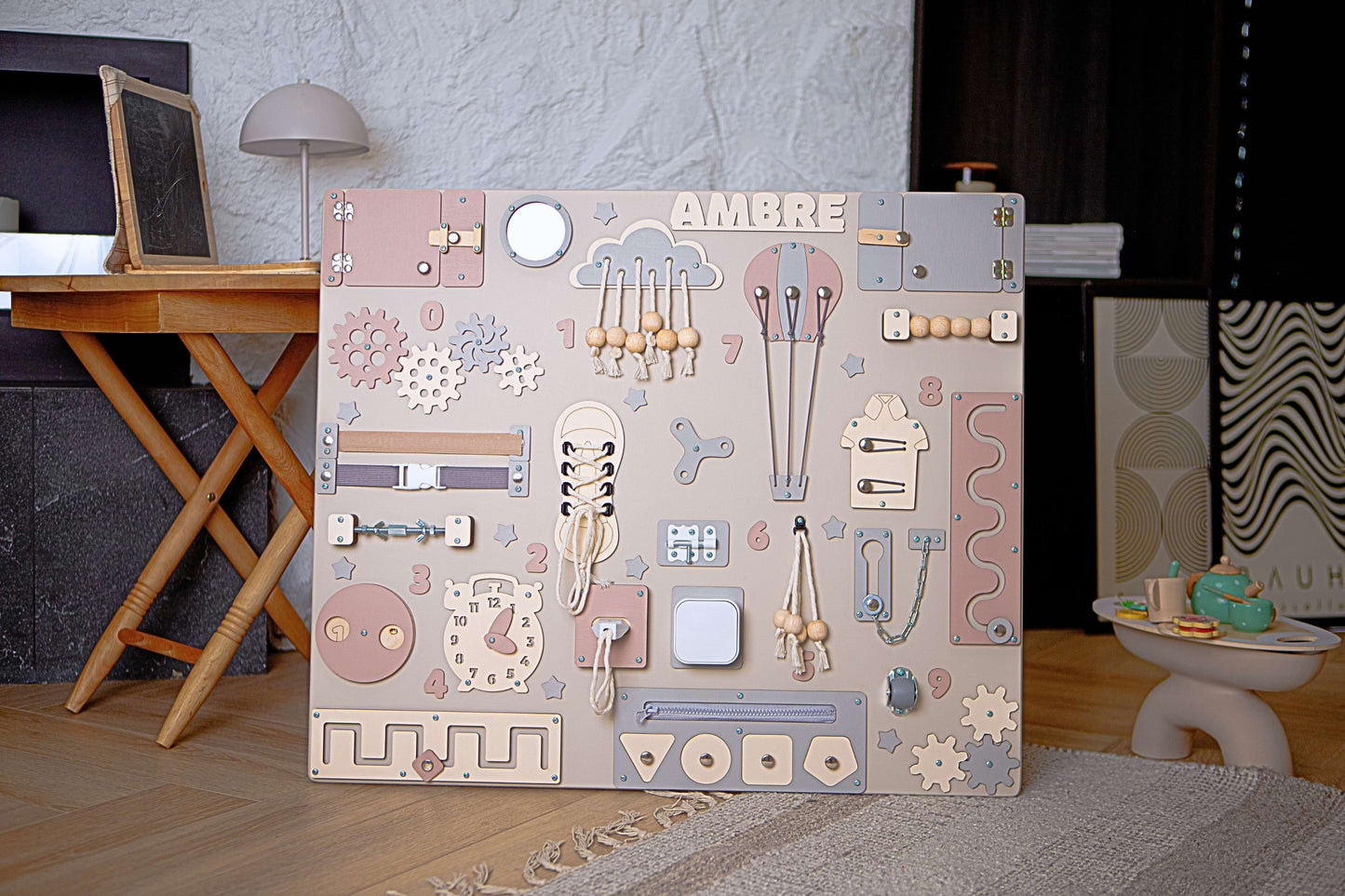 Tableau Montessori pastel pour enfants avec différentes formes et motifs sur un sol en bois.